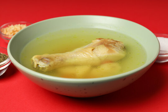 Concept of tasty food with chicken soup on red background