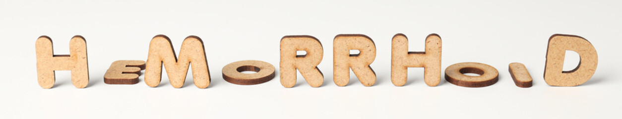 Concept of hemorrhoids with wooden letters on white background