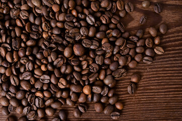Background of coffee beans. Roasted coffee beans on a wooden table. Brown coffee. Flat layout with top view