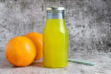 Glass bottle with orange soda on stone base and copy space.