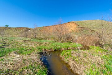Photographs of a landscape, stream, Gully is a relief created by running water, which rapidly collapses into the soil, usually on a hillside. Gullies resemble large ditches or small valleys,