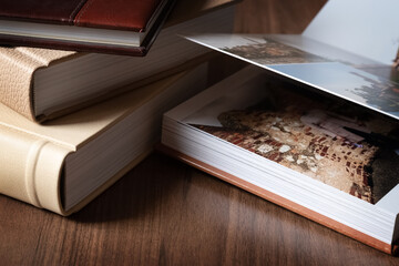 Pile of hardcover photo albums on table surface