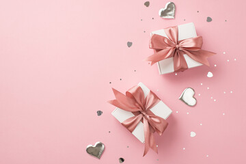 Top view photo of white gift boxes with pink satin ribbon bows silver decorative hearts sequins and...