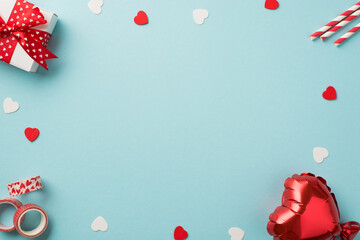 Top view photo of saint valentine's day decor giftbox with red bow straws decorative adhesive tape heart shaped balloon and confetti on isolated pastel blue background with copyspace in the middle