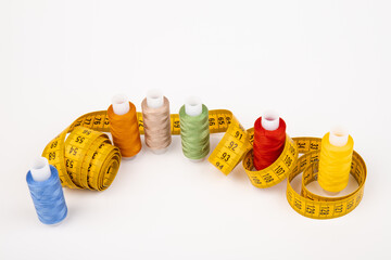 Sewing threads, sewing centimeter or measuring tape, isolated on white background.