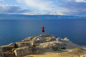 Fototapeta na wymiar Guy on a rock overlooking Lake Baikal