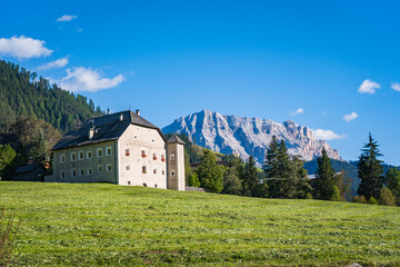 castle in front of the dolomites mountains on a sunny day