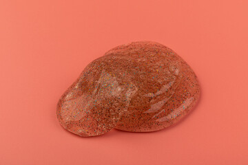 Naklejka premium Coral transparent slime with bubbles inside on pink background. Kids toy slime.