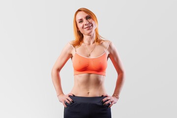 Beautiful girl with a short sports top, on a gray background