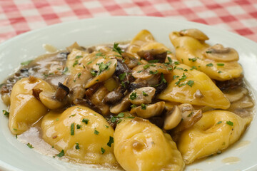 Delicious homemade ravioli filled with mushrooms and ricotta and served under sour cream sauce with porcini