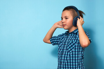 Boy listening music with headphones over blue background