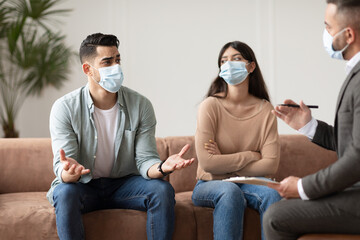 Couple talking at therapy session with male therapist