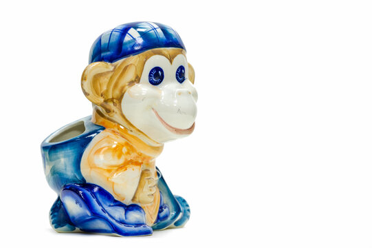 figurine of a playful monkey with a backpack and a baseball cap. Pencil holder. painted with porcelain paints. collectibles. Swap meet. Antiques, art. white ceramic translucent ceramic; China.