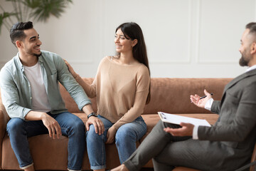 Obraz premium Happy couple reconciling at therapy session in therapists office