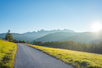 road in countryside in the dolomites mountains on a sunny early morning