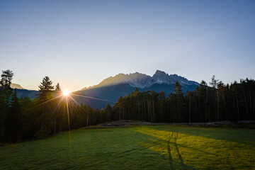 sunrise early in the morning above forest and latemar mountains in the dolomites
