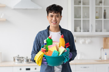 Smiling asian guy house-keeper cleaning apartment, copy space