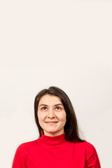 Fototapeta premium Beautiful woman in red sweater looks up, vertical banner with space for text.