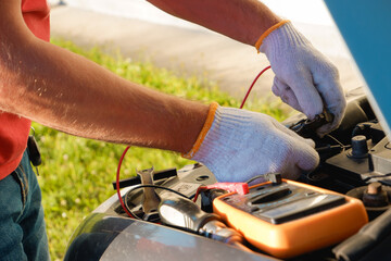Replacing the battery before winter. Car maintenance before the cold season. Close up hand of Male...