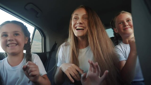 children teenagers dancing in the car on the road travel. happy family adventure a kid dream concept. friendly family sisters dancing having to fun the music in the car on the way to vacation