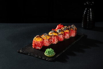 Sushi roll with fresh fish, avocado, cream cheese on black background. Sushi menu. Japanese food.