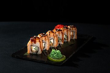 Sushi roll with fresh fish, avocado, cream cheese on black background. Sushi menu. Japanese food.