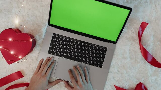 Computer su tappeto bianco con cuori e regali per san valentino