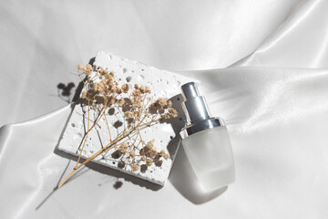 white fabric textile background with lifestyle, cosmetic makeup bottle lotion cream product with...