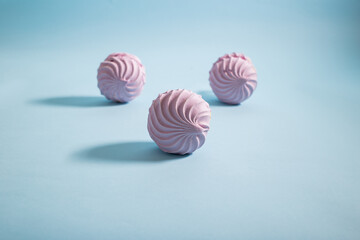 Sweet marshmallow lies on a blue background, minimalism, dessert