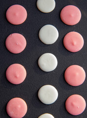 White and Pink Round Chocolate Chips Morsels or Drops Pile or Heap on Black background Circle Chocolate Candies Ingredients for Chocolate Glaze and Sweets