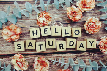 Hello Saturday alphabet letter and flower decorate on wooden background