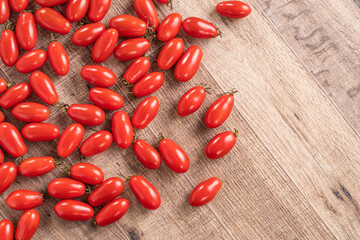 Fresh cherry tomatoes over wooden table background.