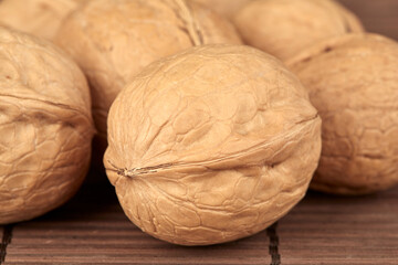 Close-ups of walnuts are lying on the table in a heap.