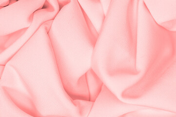 The fabric is silk of a pale red color. Texture. Background. Pattern. Silk fabric has a shiny sheen...
