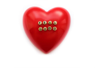 Headline Feel Good on blurred red heart on white background