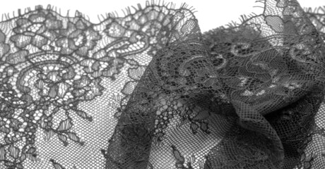 Black lace fabric on a white background.    Fancy African polyester and tulle lace fabric with...