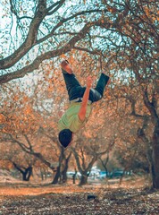 Man jumps in the air, acrobatics, orange fall of leaves