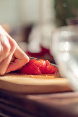 hand Cutting Tomato on plate,