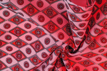 silk fabric of soft red color with a print of rhombuses, squares and medals. Tell a story and make a statement with traditional design work that has charm and value. Texture background pattern