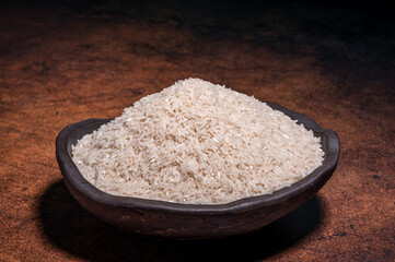 The white rice in the bowl is on the dark background