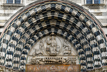 Lunette of the central portal of the Cathedral of San Lorenzo with Christ the Judge surrounded by the symbols of the four Evangelists and below, the Martyrdom of San Lorenzo, Genoa, Liguria, Italy - obrazy, fototapety, plakaty