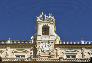 Detail of the façade of Palazzo Doria-Tursi, seat of the town hall of Genoa, with the city's coat of arms, sculptures and flags, Liguria, Italy