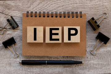 I.E.P. Individualized Education Plan. stamp blocks. text on wood blocks. wood blocks on notepad....
