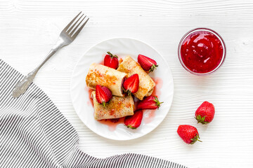 Hot rolled pancakes with strawberry and berry sauce