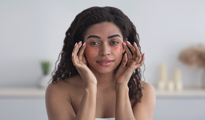 Attractive woman apply anti-fatigue under eye mask, skin care, lady touch patches under eyes to...