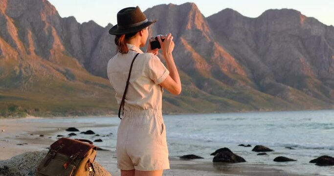 photographer girl take photo on camera closeup on background foggy mountain, tourist shooting nature mist landscape, hobby concept, copy space. a girl in a safari hat makes a photo at the ocean sunset