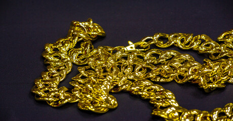 Gold chain to be worn around the neck. A chain is a sequential assembly of connected parts, made of gold, with an overall character similar to that of rope in that it is flexible and curved