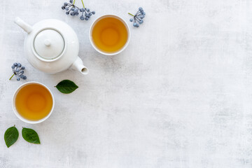 Obraz na płótnie Canvas Two cups of tea with white teapot, top view