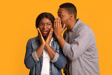 Portrait Of Black Guy Sharing Secret With His Confused Girlfriend