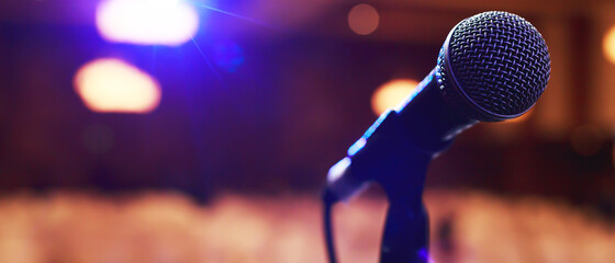 Close up of microphone on stage lighting at concert hall or conference room. copy space banner. soft focus. - obrazy, fototapety, plakaty